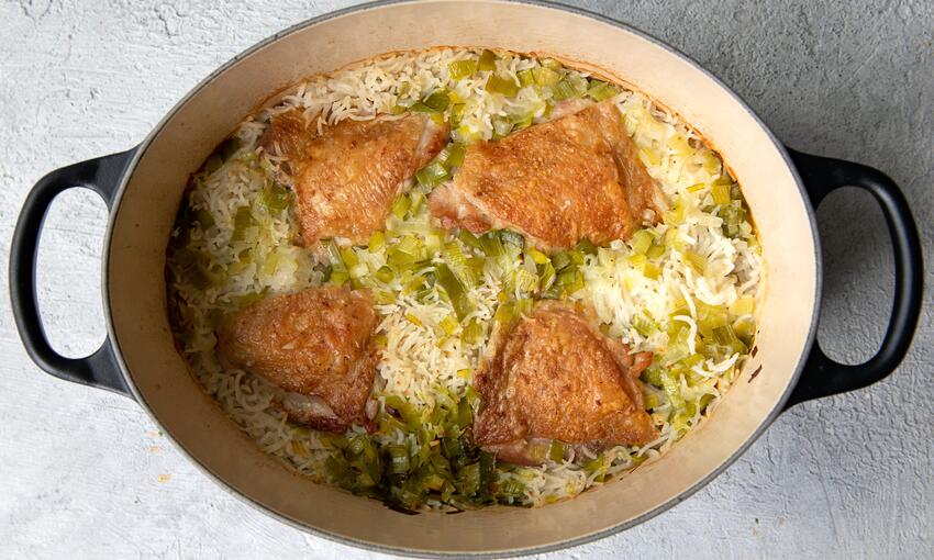 roast chicken, fragrant rice and tender leeks cooked in casserole dish 