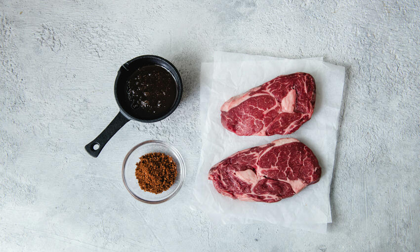 raw rib eye steak and spices