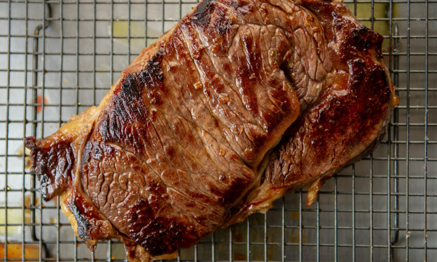 cooked steak on resting board