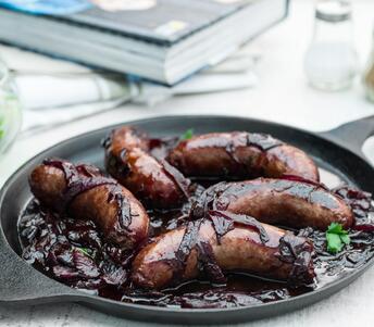 cooked boar sausage with glazed onions