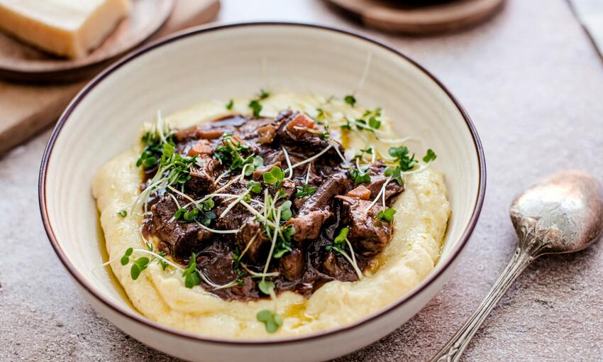 cook tuscan beef stew in creamy polenta